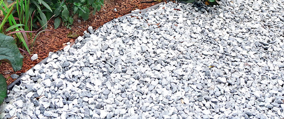 A gorgeous white and gray granite rock landscape bed installation.