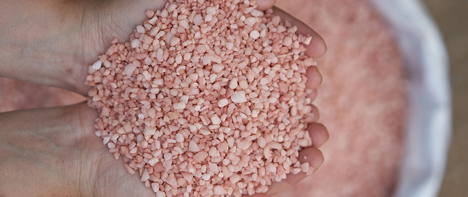 Potassium granular fertilizer in a person's hands.