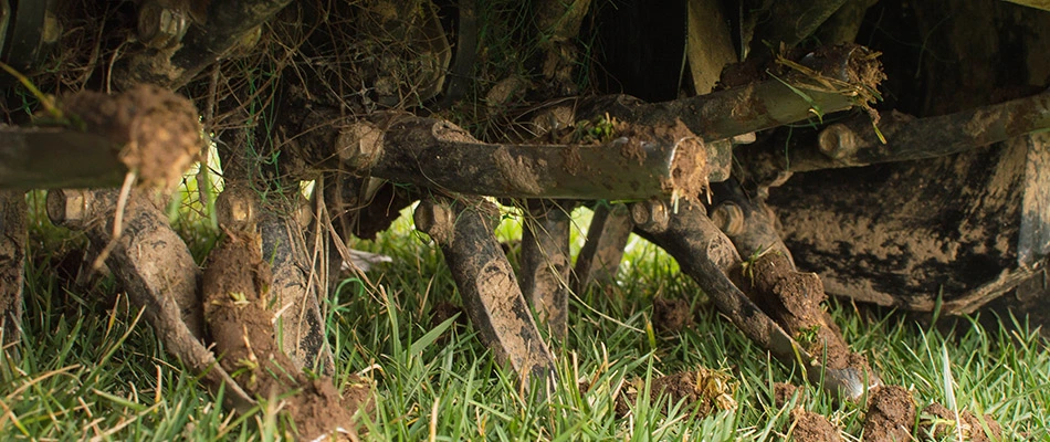 An underneath view of a premium core aerator machine in a lawn in The Villages, FL.